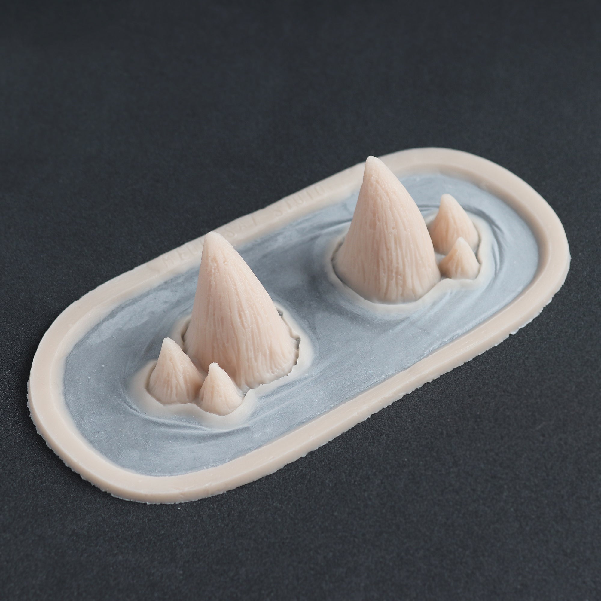 Triple Devil Horns - Silicone makeup prosthetic in vanilla shade on a black surface