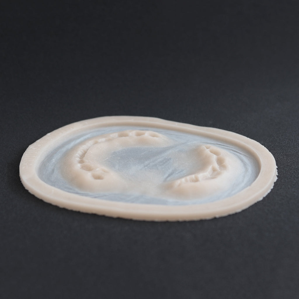 Zombie Bite - Silicone makeup prosthetic in vanilla shade on a black surface