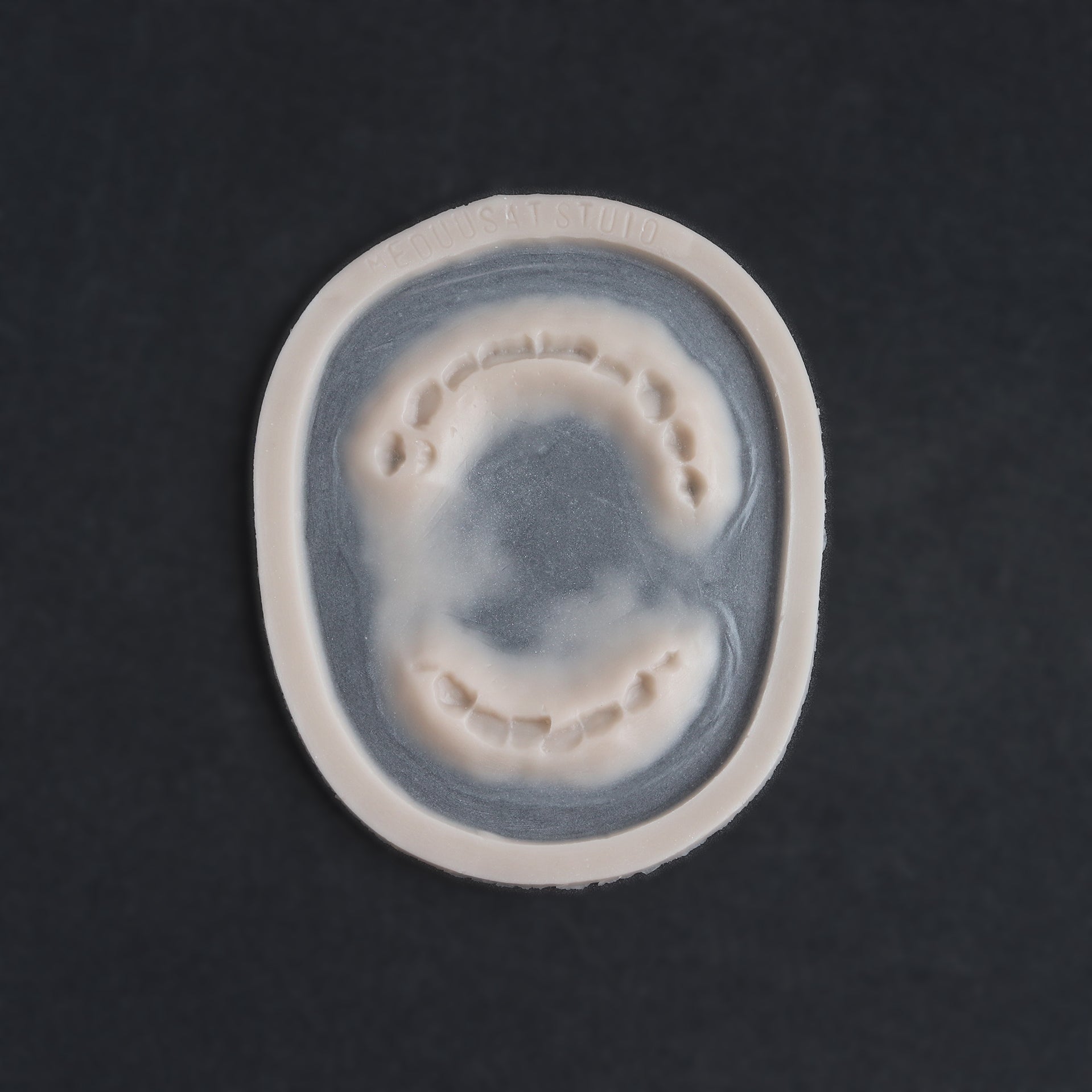 Zombie Bite - Silicone makeup prosthetic in vanilla shade on a black surface